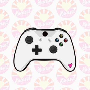 May include: A white Xbox controller with black buttons and a pink heart sticker on the bottom right corner.