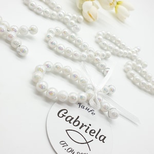 Może przedstawiać: Bransoletki z białych pereł z białą wstążką i etykietą z napisem "Taufe Gabriela 07.04.2021".