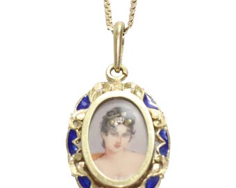 May include: A gold pendant necklace with a blue enamel oval frame. The frame contains a miniature portrait of a woman with dark hair and a jeweled headband.