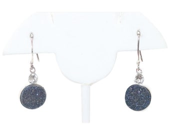 May include: A pair of silver dangle earrings with a round, dark blue stone and a small clear crystal accent.