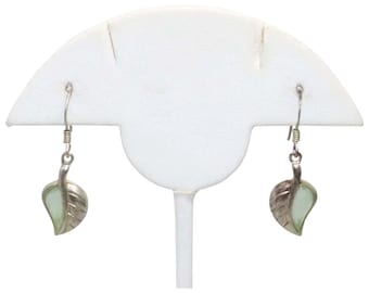 Può includere: Un paio di orecchini a forma di foglia d'argento con una pietra verde chiaro al centro di ogni foglia.