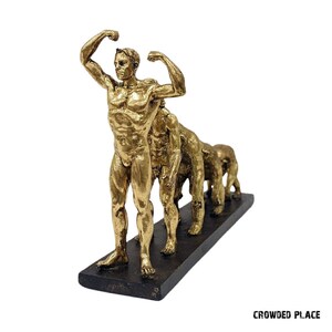 May include: Gold-toned figurine depicting the evolution of humans, starting with a primitive ape-like figure and progressing to a modern human figure. The figures are arranged in a line on a black base.