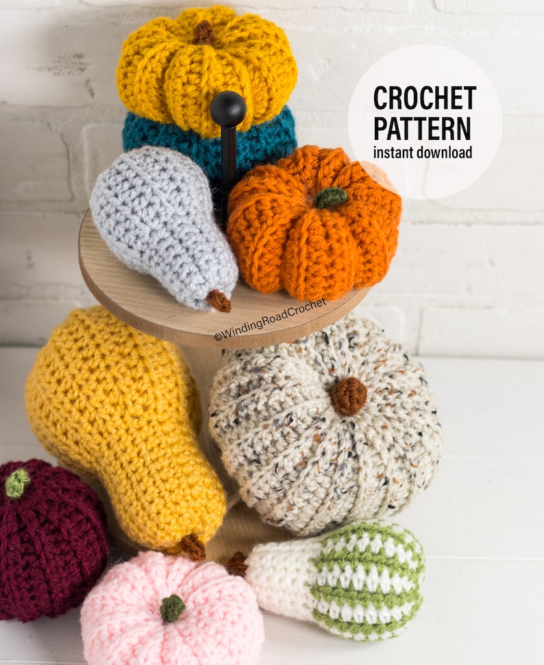 Puede incluir: Una colecci&oacute;n de calabazas y peras de ganchillo en varios colores, incluyendo amarillo, naranja, gris, blanco, verde y rosa. Las calabazas y las peras est&aacute;n dispuestas en un soporte de madera de dos niveles. La imagen incluye el texto "CROCHET PATTERN instant download".