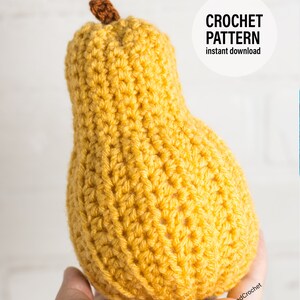 Puede incluir: Una pera de crochet de color amarillo, sostenida en una mano. La pera tiene un tallo marr&oacute;n. El texto "CROCHET PATTERN instant download" es visible en la imagen.