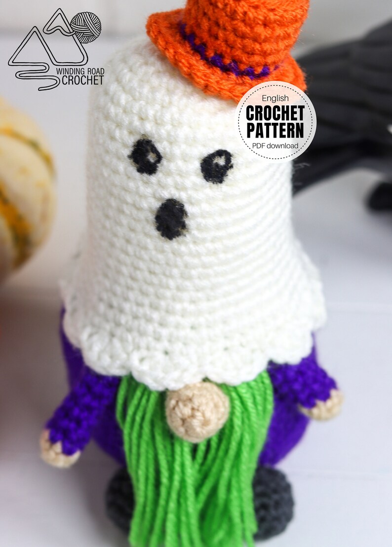 K&ouml;nnte beinhalten: Geh&auml;kelter Geist-Zwerg mit einem orangefarbenen Hut mit violettem Rand. Der Zwerg hat einen violetten K&ouml;rper, einen gr&uuml;nen Bart und eine braune Nase. Der Text "English Crochet Pattern PDF download" befindet sich auf einem wei&szlig;en Kreis.