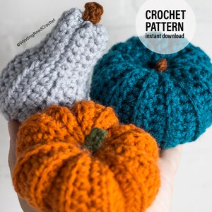 Puede incluir: Tres calabazas de ganchillo en diferentes colores: gris, azul verdoso y naranja. Las calabazas se sostienen en una mano. El texto "CROCHET PATTERN instant download" est&aacute; en la esquina superior derecha de la imagen.