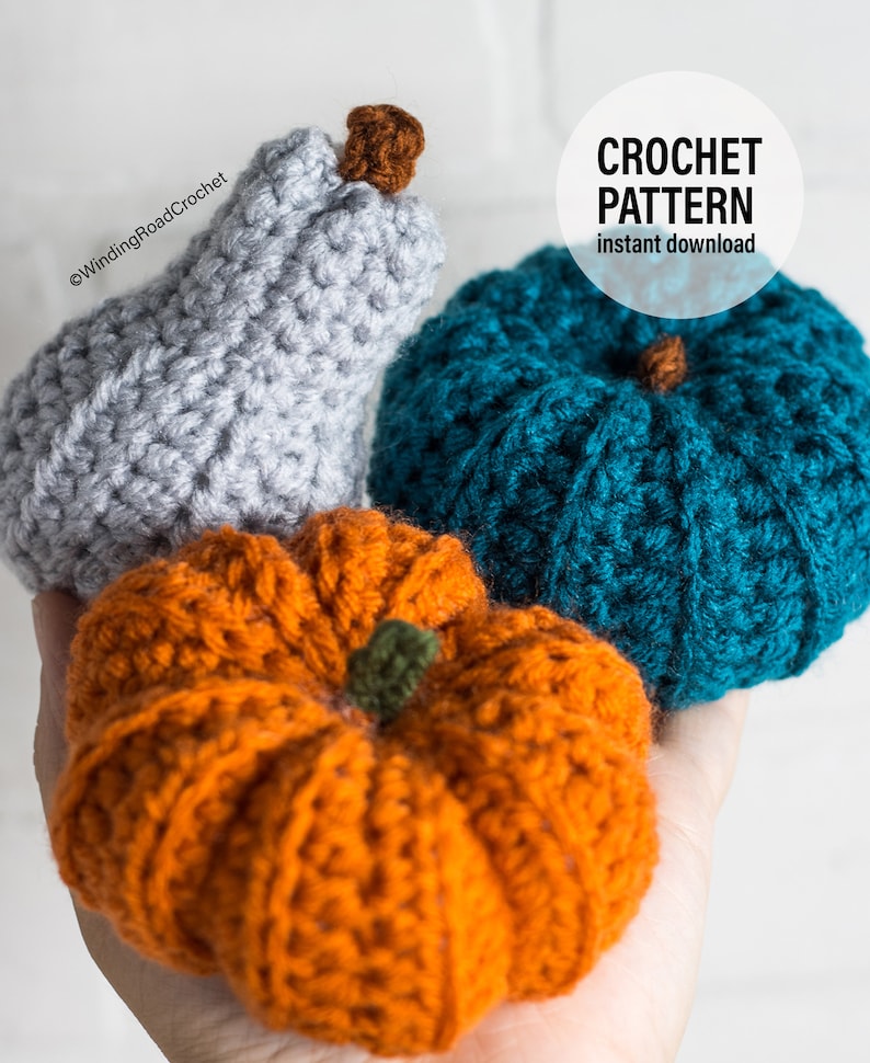 Puede incluir: Tres calabazas de ganchillo en diferentes colores: gris, azul verdoso y naranja. Las calabazas se sostienen en una mano. El texto "CROCHET PATTERN instant download" est&aacute; en la esquina superior derecha de la imagen.