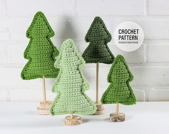 May include: Four crocheted Christmas trees in green shades, standing on wooden bases. The trees are arranged on a white surface. The text "CROCHET PATTERN instant download" is visible in a white circle.
