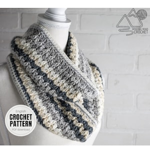 Op de afbeelding: Een grijze, witte en beige gehaakte cowl-hals sjaal. De sjaal is op een wit mannequin tegen een witte bakstenen muur. De tekst "English Crochet Pattern PDF download" staat op een witte cirkel met een zwarte rand. De tekst "Winding Road Crochet" staat op een witte driehoek met een zwarte rand.
