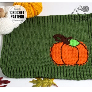 May include: Green crochet pumpkin applique with orange and brown details. The applique is on a green crochet fabric. The text "English Crochet Pattern PDF download" is on a white circle.