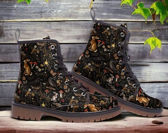 May include: A pair of black lace-up boots with a woodland-themed print featuring rabbits, birds, and flowers. The boots have a brown rubber sole.