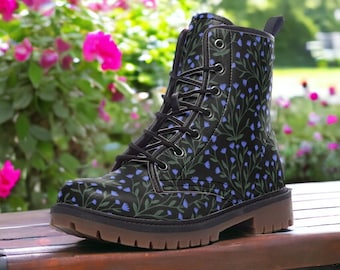 May include: Black lace-up boots with a floral pattern featuring blue flowers and green leaves on a black background.