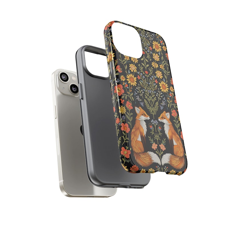May include: A phone case with a black background featuring a floral pattern and two orange foxes. The case is designed to fit a smartphone, with cutouts for the camera and buttons. The phone case is shown with a silver smartphone.
