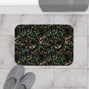May include: Black bath mat with a floral pattern featuring green leaves, pink flowers, and butterflies.