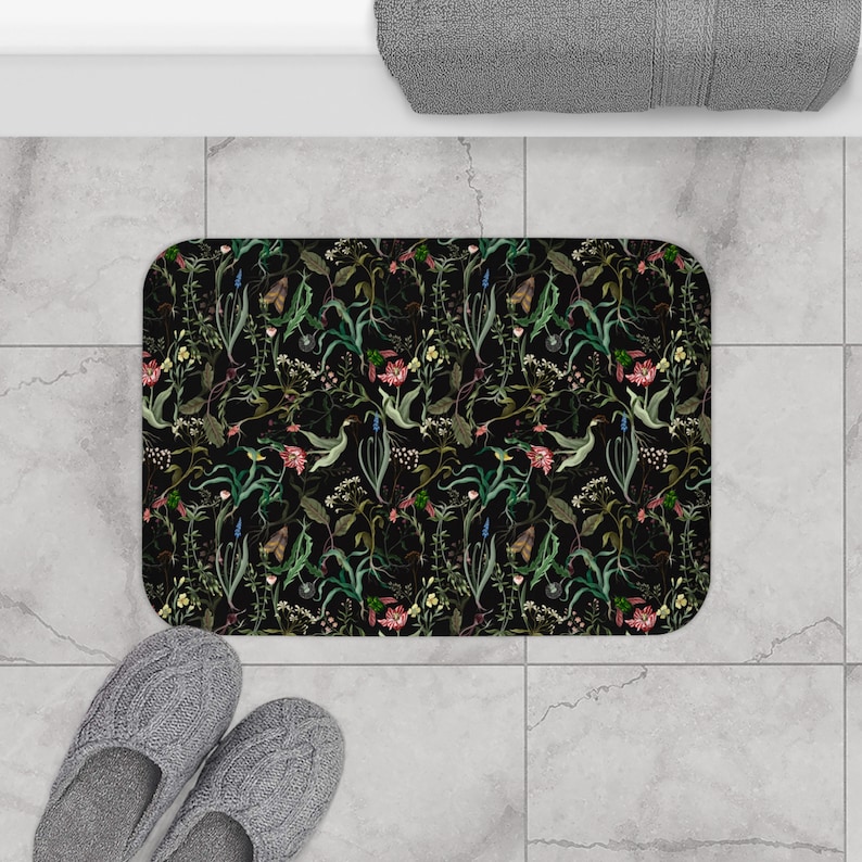 May include: Black bath mat with a floral pattern featuring green leaves, pink flowers, and butterflies.