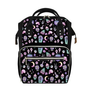 May include: A black canvas diaper bag with a whimsical pattern featuring skulls, ghosts, potion bottles, cupcakes, and the text "I see through you" and "Do not disturb".
