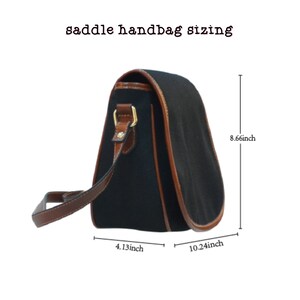 Op de afbeelding: Zwarte canvas zadeltas met bruine leren details en een gouden gesp. De tas is 8,66 inch hoog, 10,24 inch breed en 4,13 inch diep.