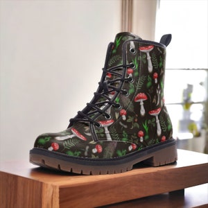 May include: Black leather lace-up boots with a green and red mushroom print.