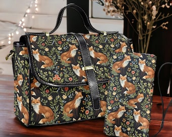 May include: A black leather handbag with a fox and floral pattern. The bag has a top handle and a shoulder strap. It comes with a matching smaller pouch.