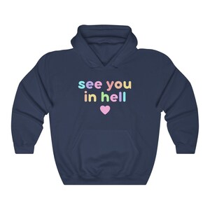 May include: Navy blue hoodie with the text "see you in hell" in rainbow colours and a pink heart.