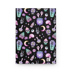 K&ouml;nnte beinhalten: Ein schwarzer Hintergrund mit einem sich wiederholenden Muster aus verschiedenen gruseligen und niedlichen Halloween-Illustrationen. Die Illustrationen beinhalten einen Sarg, einen Kessel, einen Geist, einen Sch&auml;del, einen Cupcake, eine Kristallkugel, eine Zaubertrankflasche, einen Halbmond, ein Herz, ein Peace-Zeichen und einen Stern. Die Illustrationen sind in den Farben Lila, Rosa, Blau und Gr&uuml;n gehalten.