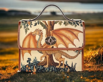 May include: A structured handbag featuring a cream-colored fabric panel with a printed illustration of a golden dragon standing beside a tree. The bag has brown leather-like trim, a single top handle, and a central silver-toned metal twist-lock closure.