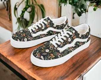 May include: A pair of black canvas low-top sneakers with white laces and a white sole. The sneakers feature a floral print with mushrooms, leaves, and daisies.