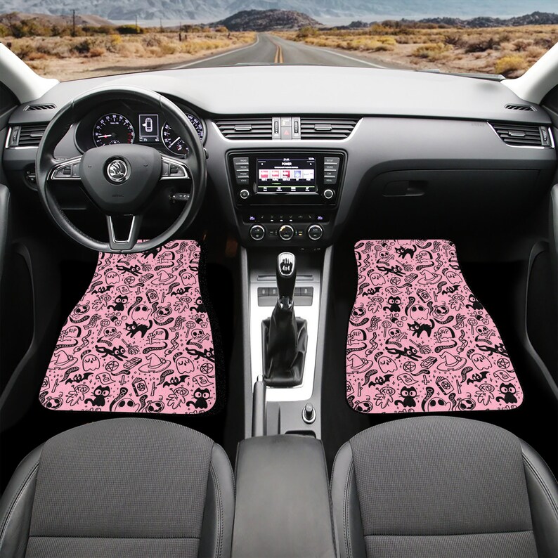 May include: Two pink car floor mats with a black and white pattern of ghosts, bats, cats, and other Halloween symbols.