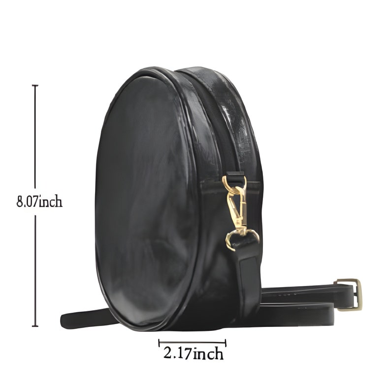 Puede incluir: Bolso bandolera negro y redondo con acabado brillante. El bolso mide 20,5 cm de alto y 5,5 cm de ancho. Cuenta con un cierre dorado y una correa ajustable. El bolso est&aacute; dise&ntilde;ado para llevar lo esencial.