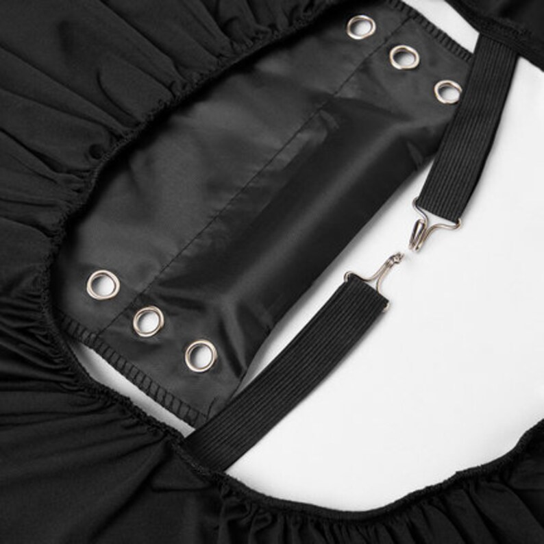 May include: Black fabric with adjustable straps and metal eyelets. The straps are attached to the fabric with metal hooks.