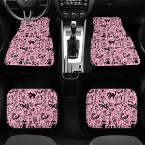 May include: Set of four pink car floor mats with a black and white spooky Halloween pattern. The pattern includes ghosts, bats, cats, skulls, and other spooky symbols.