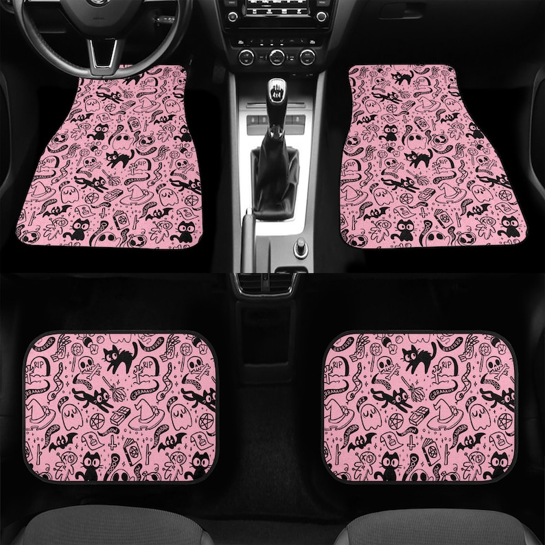 May include: Set of four pink car floor mats with a black and white spooky Halloween pattern. The pattern includes ghosts, bats, cats, skulls, and other spooky symbols.