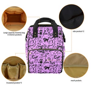 May include: Purple diaper bag with a black and white print of ghosts, cats, and other Halloween-themed imagery. The bag has multiple pockets, including insulated pockets, side pockets, and mesh pockets.