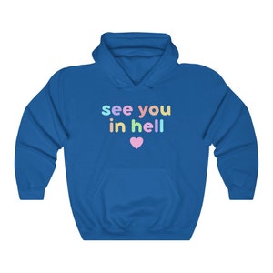 May include: A royal blue hoodie with a white heart and the text "see you in hell" in rainbow colours.