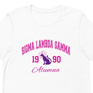 May include: White t-shirt with pink text that reads "Sigma Lambda Gamma 1990 Alumna". A purple silhouette of a panther with a rose is between the years.
