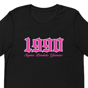 May include: Black t-shirt with a pink 1990 in a gothic font and the text "Sigma Lambda Gamma" below.