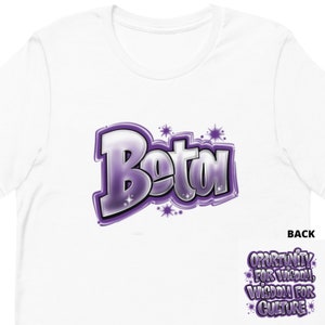 Könnte beinhalten: Weißes T-Shirt mit einer lila und silbernen Grafik des Wortes "Beta" mit Sternen. Die Rückseite des Shirts zeigt den Text "Opportunity for Wisdom, Wisdom for Culture" in Lila.