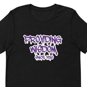Puede incluir: Camiseta negra con un gráfico morado que dice "Providing Wisdom Since 1986".