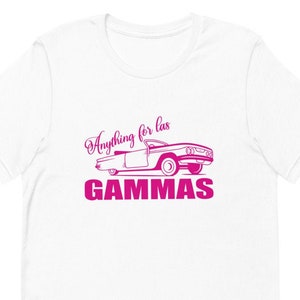 May include: White t-shirt with a pink graphic of a vintage car and the text "Anything for las GAMMAS".