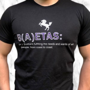 Könnte beinhalten: Ein schwarzes T-Shirt mit einem weißen Pferde-Motiv und dem Text "B(A)ETAS: (n.) Brüder, die die Bedürfnisse und Wünsche aller Menschen erfüllen, von Küste zu Küste."