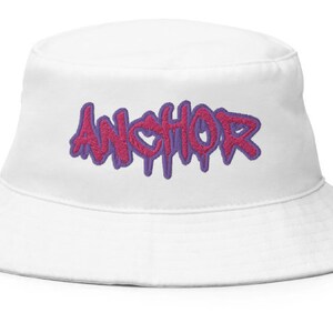 May include: White bucket hat with a pink and purple "ANCHOR" graphic.
