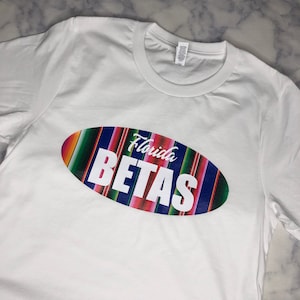 May include: White t-shirt with a colorful oval graphic that says "Florida Betas" in white text.