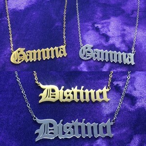 May include: Two gold and two silver necklaces with nameplates. The nameplates are in a gothic font. The gold nameplates read "Gamma" and "Distinct". The silver nameplates read "Gamma" and "Distinct".
