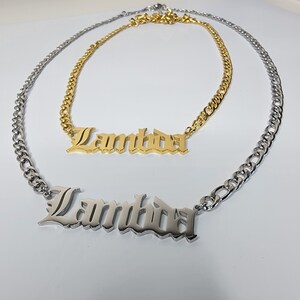 May include: Two gold and silver necklaces with the word "Lambda" in a gothic font.