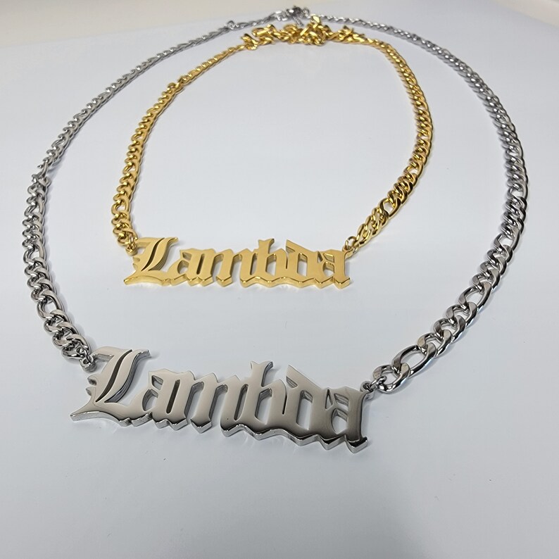 May include: Two gold and silver necklaces with the word "Lambda" in a gothic font.