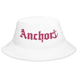 May include: White bucket hat with a pink embroidered anchor and the word "Anchory" in a gothic font.