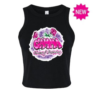 May include: Black tank top with a pink and white graphic design featuring the word "GAMMA" and the text "Woman of Distinction".