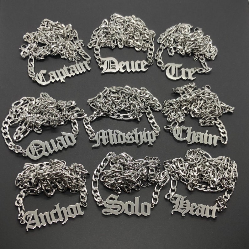 K&ouml;nnte beinhalten: Neun silberne Halsketten mit verschiedenen Namen in altdeutscher Schrift. Die Namen sind Captain, Deuce, Tre, Quad, Midship, Chain, Anchor, Solo und Heart.