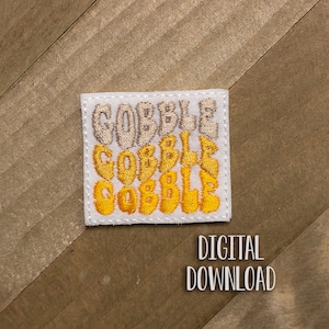 May include: White square patch with the word "GOBBLE" embroidered in yellow and beige, stacked three times, with the top word in beige and the bottom two in yellow. The patch has a white border.