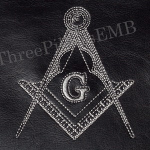 May include: A black leather patch with a white embroidered Masonic symbol, a compass and square with a 'G' in the center. The text 'Three Peaks EMB' is embroidered in white on the top right corner.